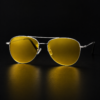 ZOE silver aviator night driving glasses with yellow lenses on a dark surface